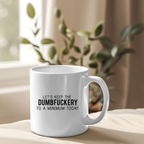 White mug with text on a surface with a plant in the background