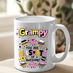 White mug with colorful text and graphics on a beige surface with a blurred plant background