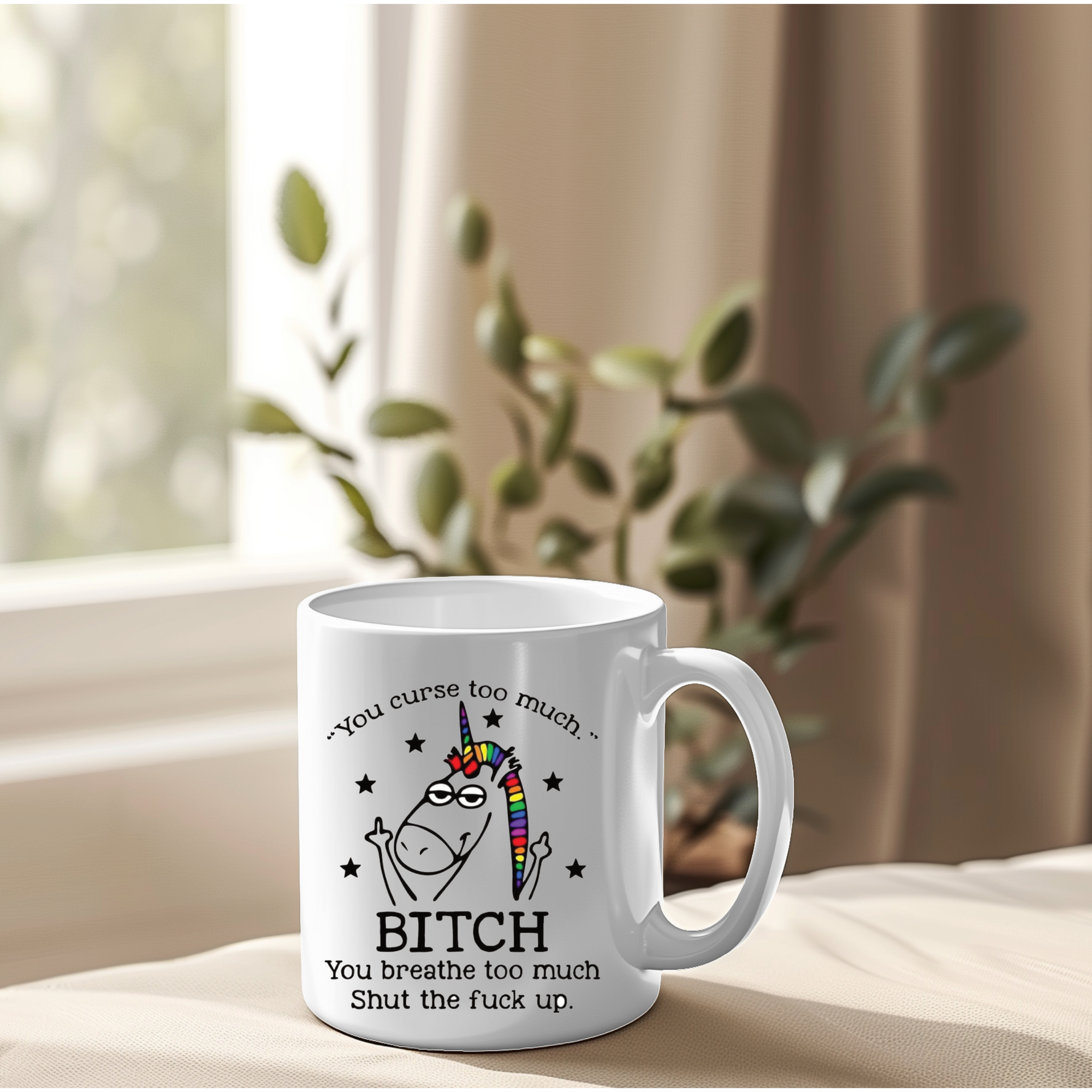 White mug with a graphic design and text on a surface with a plant in the background