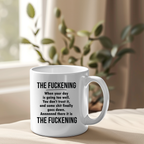 White mug with black text on a beige surface with a plant in the background